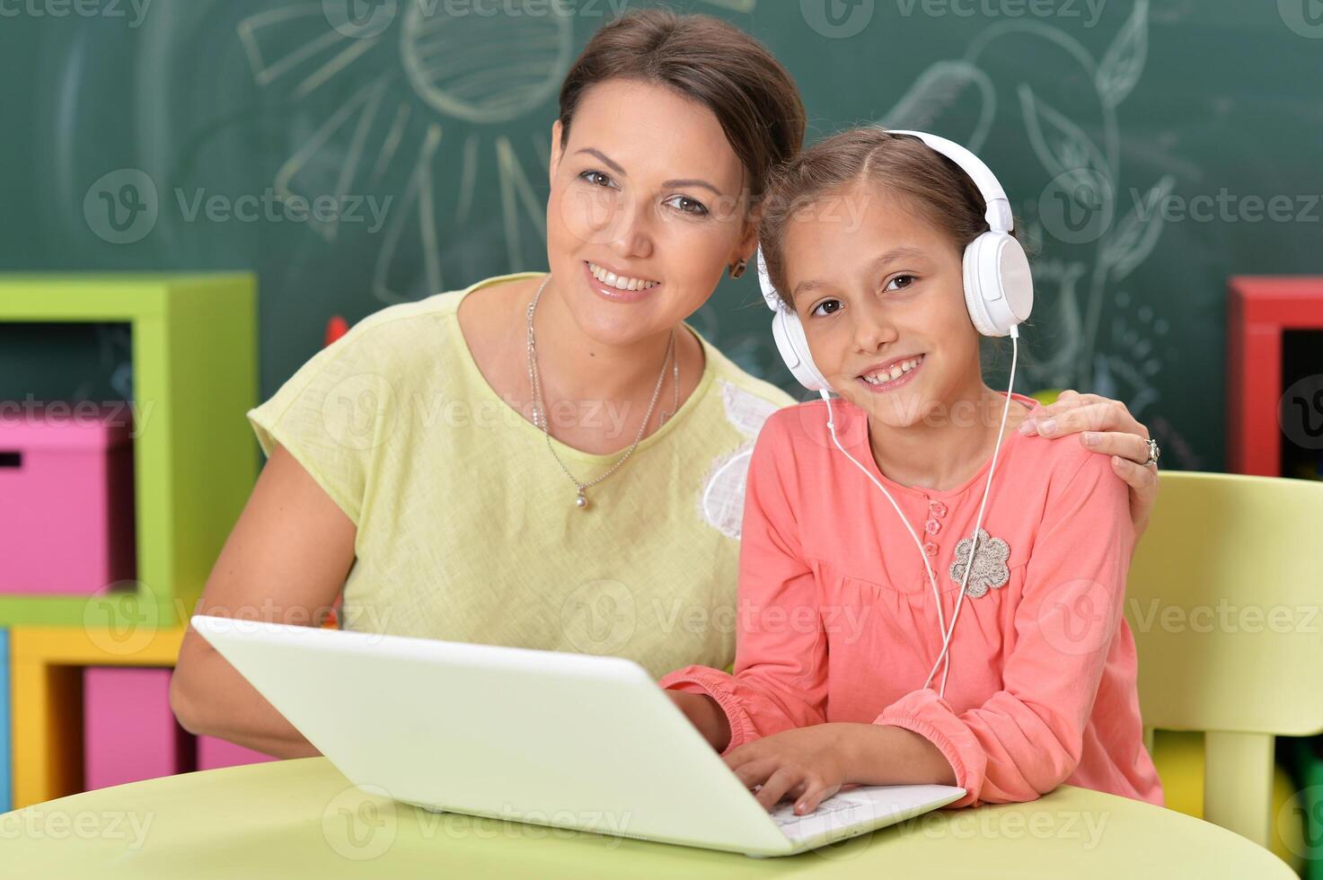 Portrait of mother and daughter using laptop photo