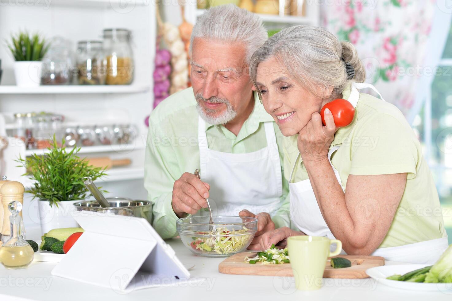 Portrait of a senior couple cooking in kitchen photo