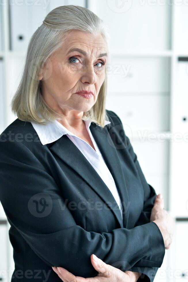 Portrait of thoughtful senior business lady in office photo