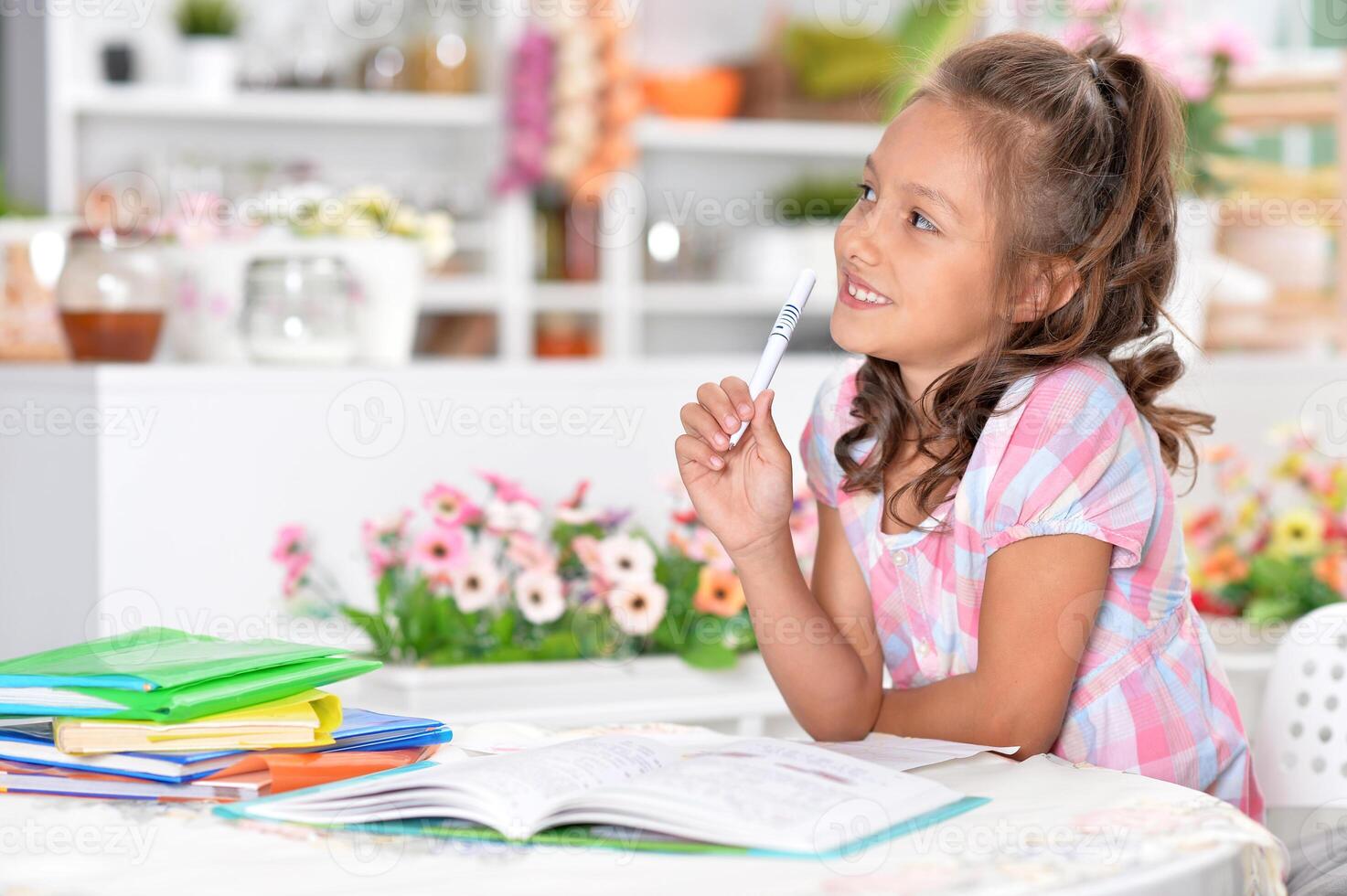 Portrait of happy schoolgirl studying at home photo