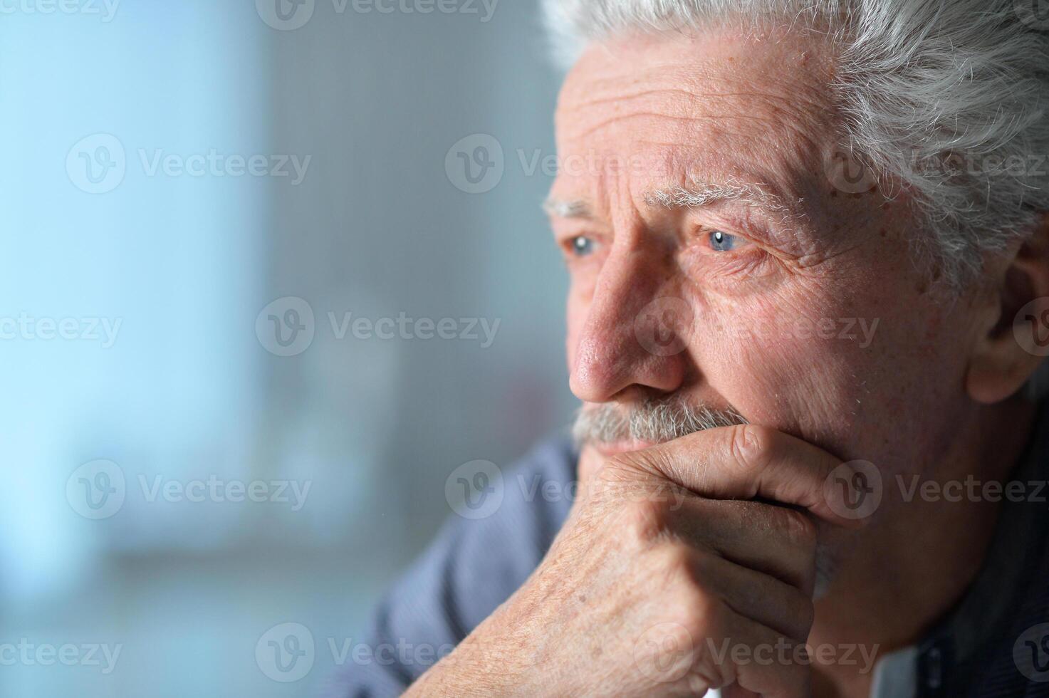 Portrait of old sad man at home photo