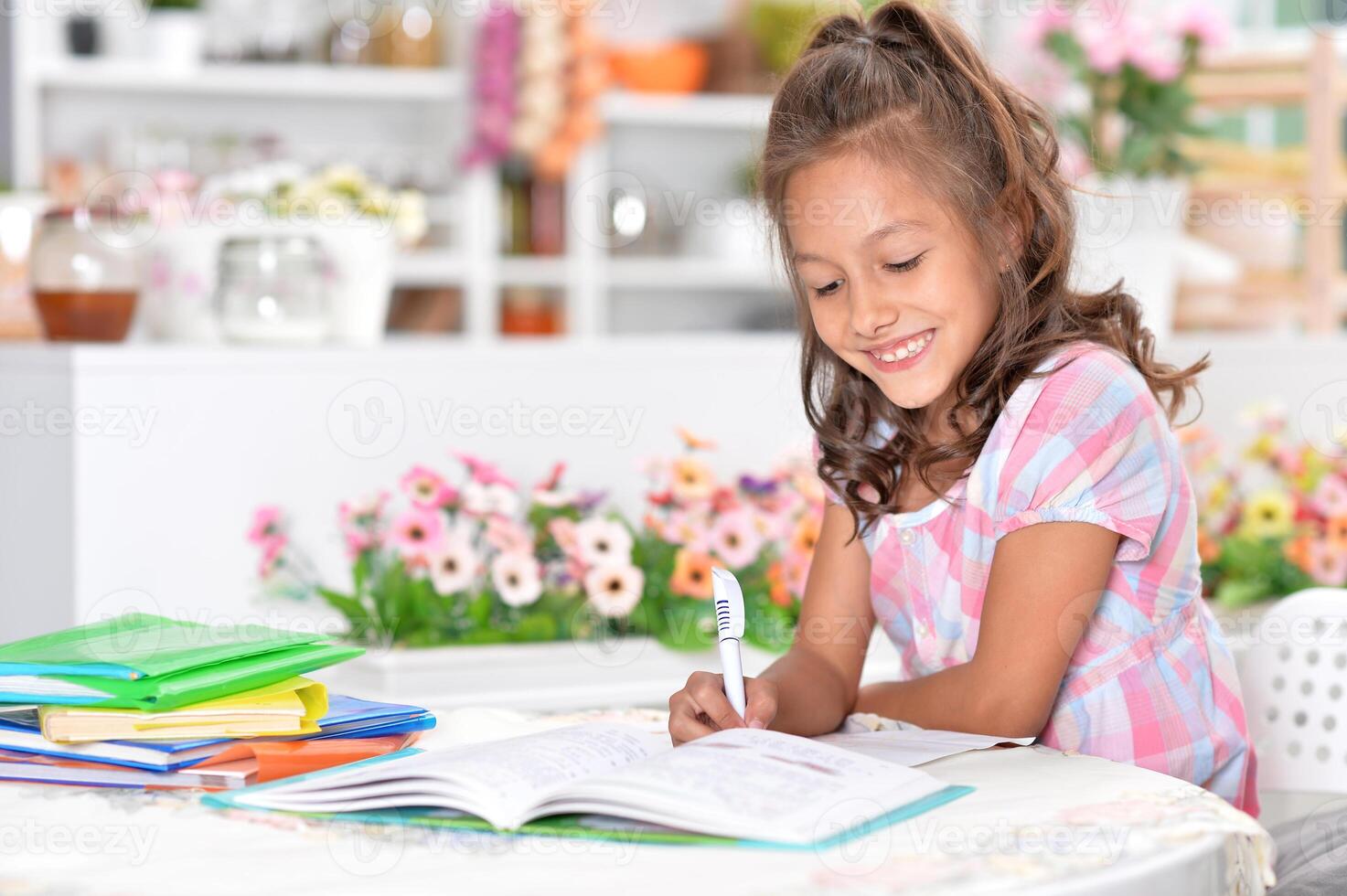 Portrait of happy schoolgirl studying at home photo