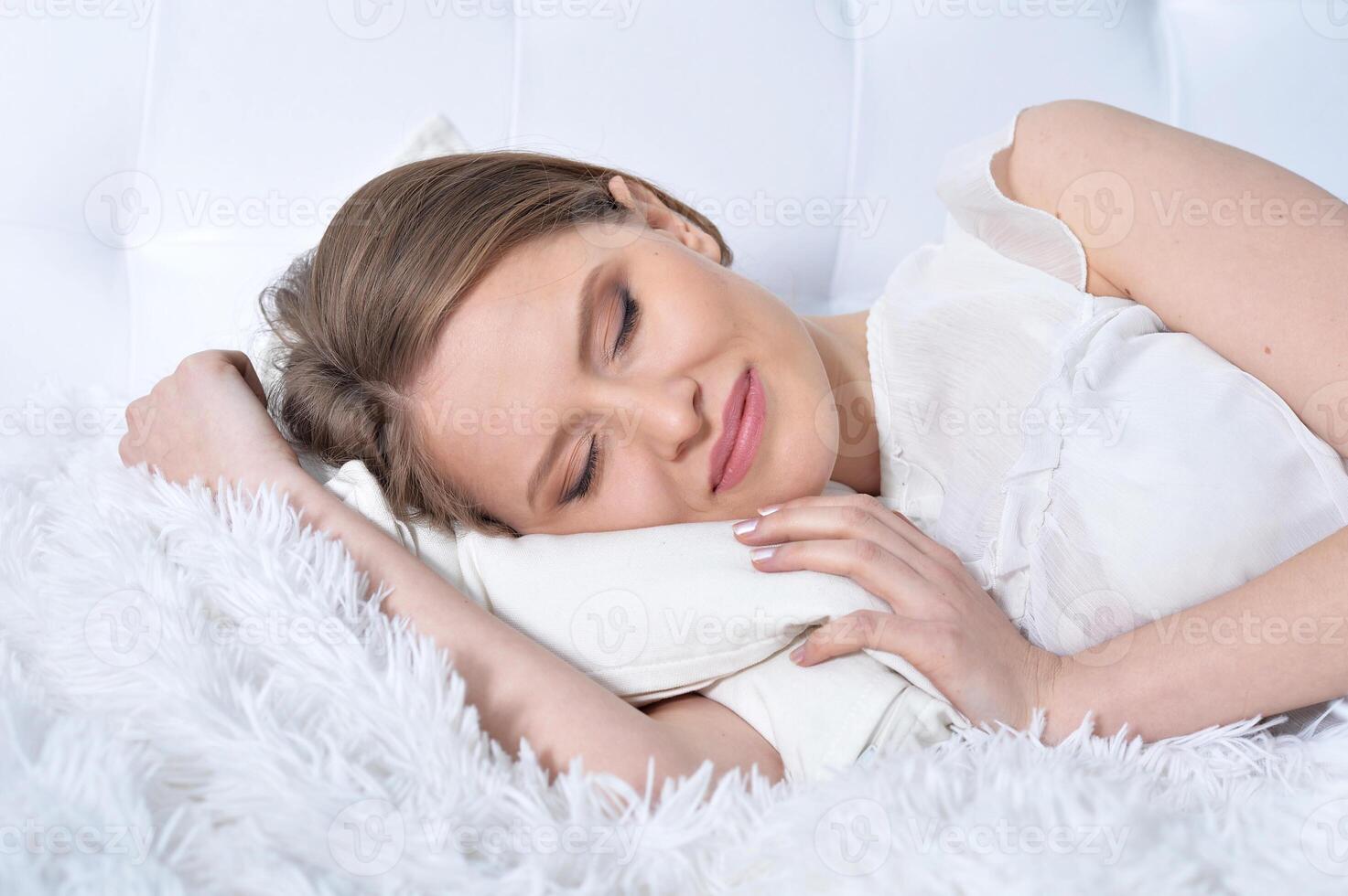 Portrait of young woman sleeping in bed at home photo