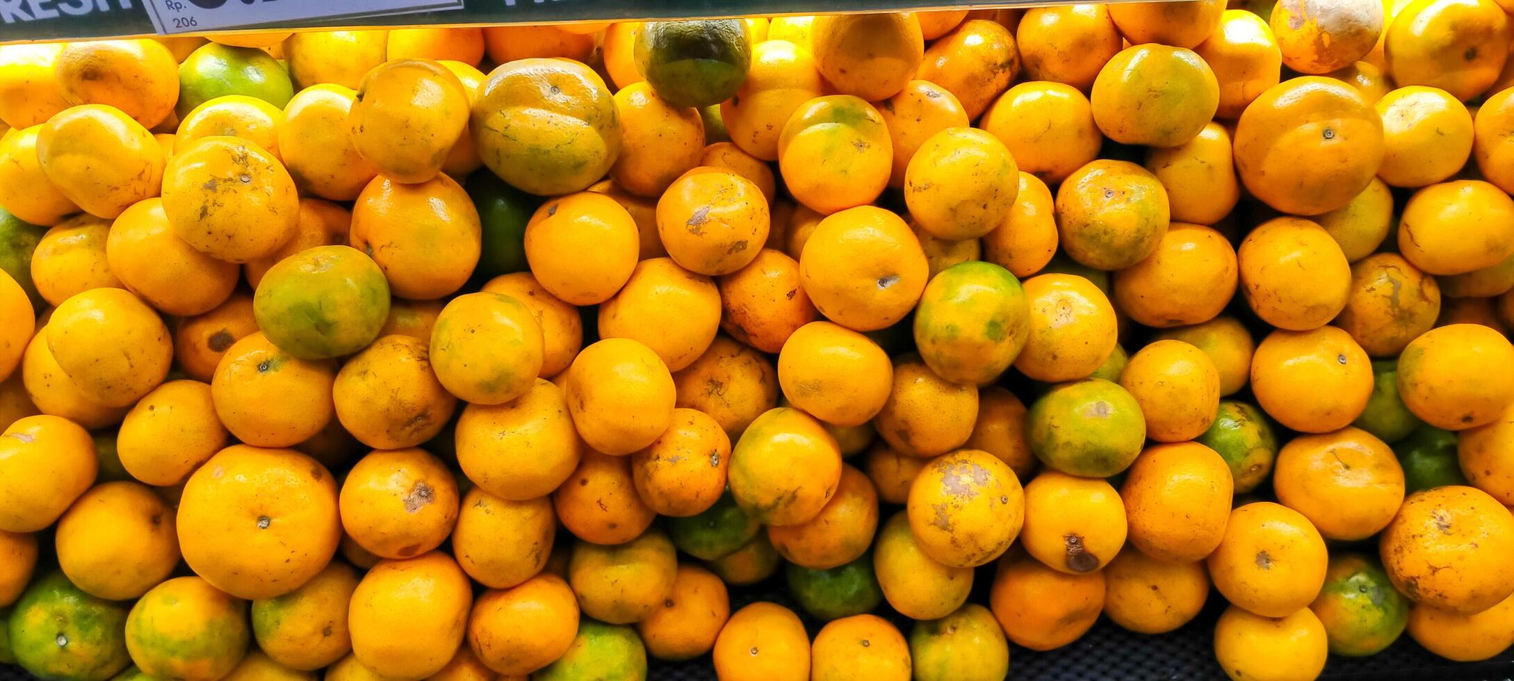 Arrangement of yellow oranges in a supermarket photo