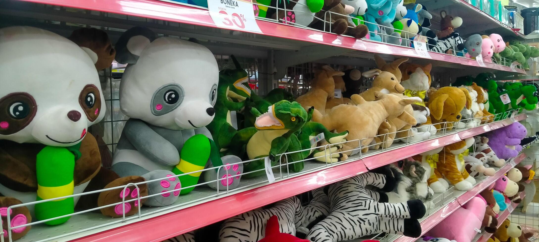 an arrangement of various stuffed animals in one of the display cases in a supermarket photo