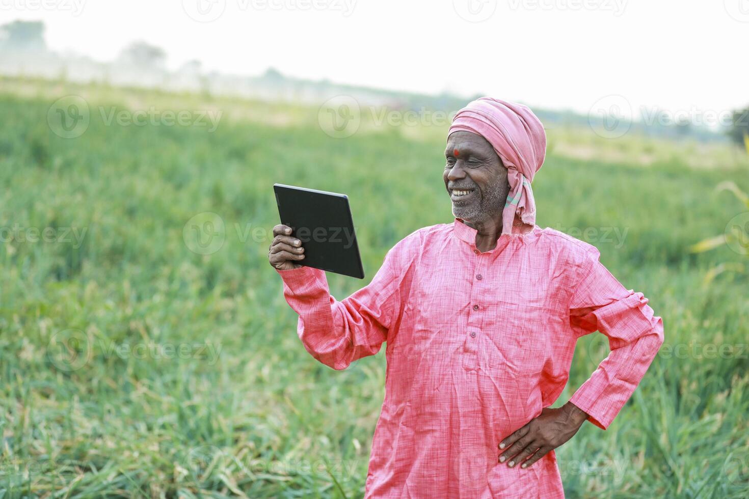 Indian farm worker holding tablet photo