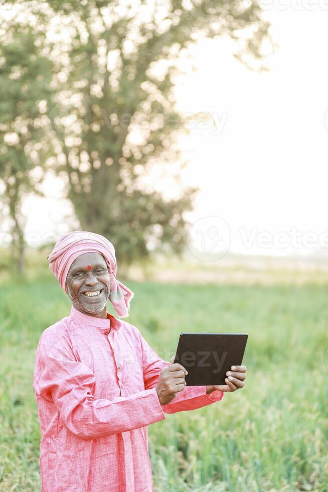 Indian farm worker holding tablet photo
