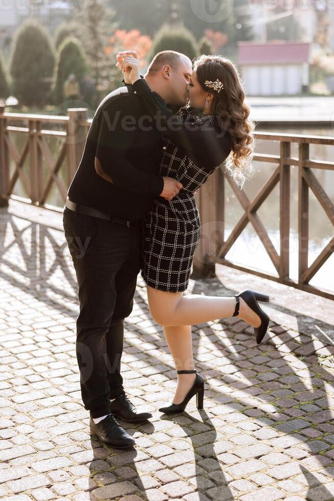 A man and woman are kissing on a bridge photo