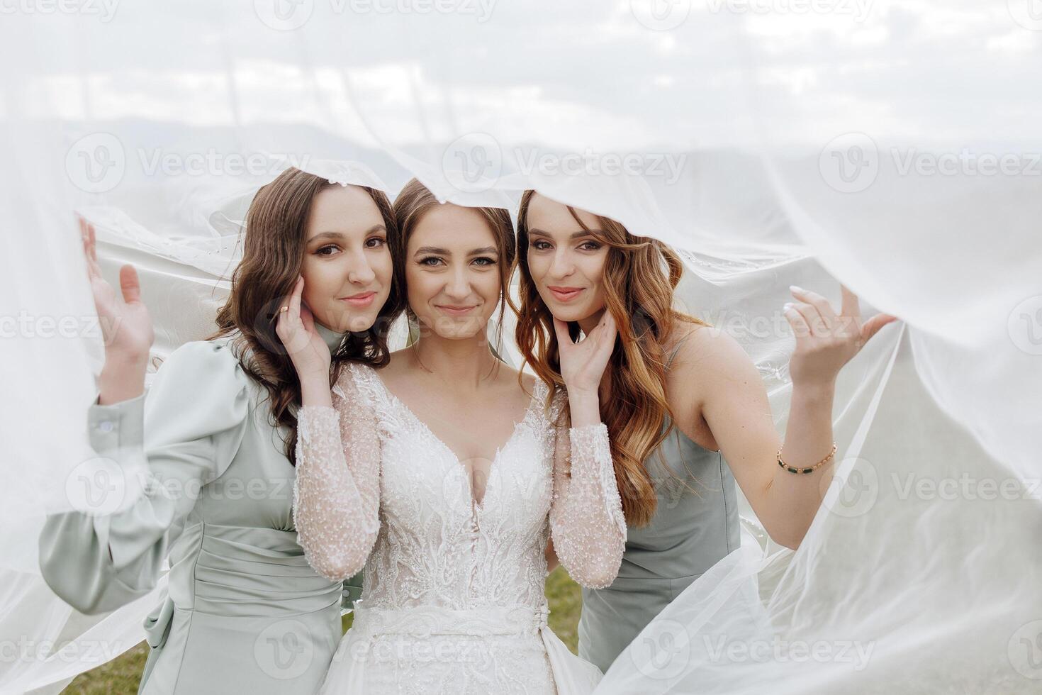 Three women are posing for a photo, with one of them wearing a wedding dress. The photo is taken from behind, with the women's faces partially hidden by a white cloth. Scene is lighthearted and fun