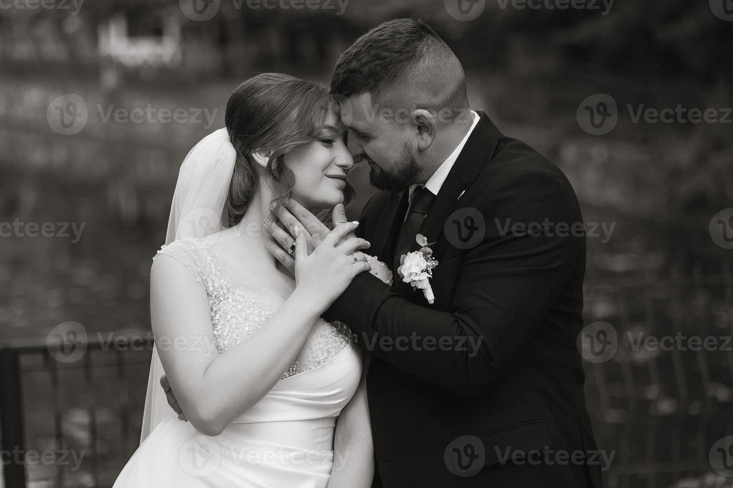 A bride and groom are embracing each other in a black and white photo