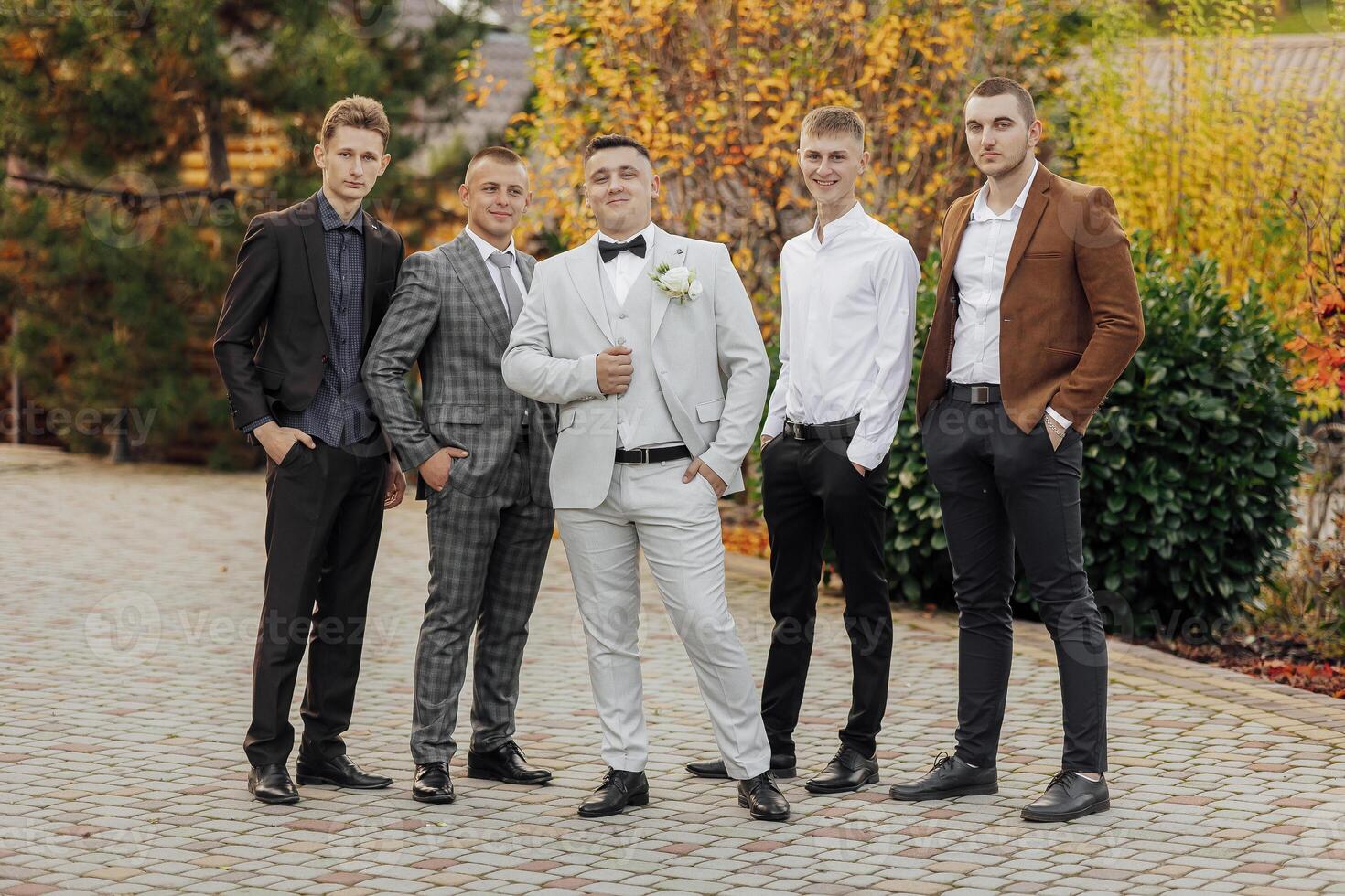 A group of men are dressed in suits and ties, posing for a photo. Scene is formal and professional photo