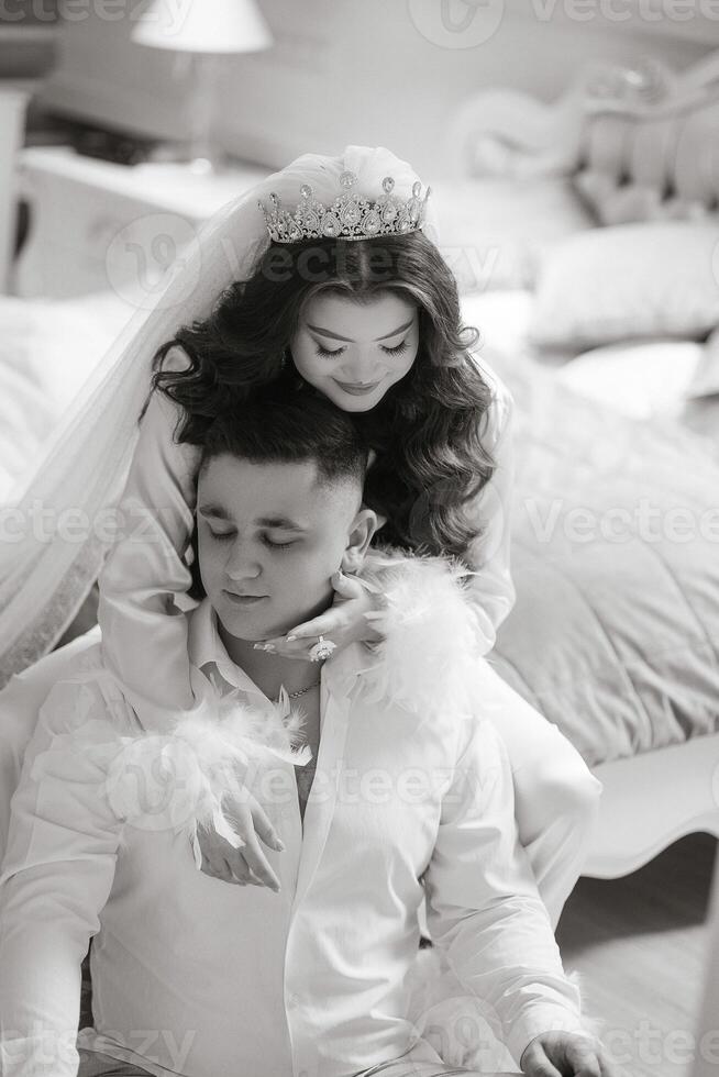 A man and woman are posing for a picture, with the woman wearing a crown. The man is sitting on the woman's shoulders photo