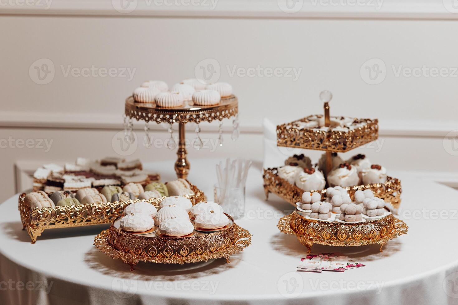 A table with a variety of desserts, including cupcakes and donuts. The table is set for a special occasion, and the desserts are arranged in a way that is visually appealing and inviting photo