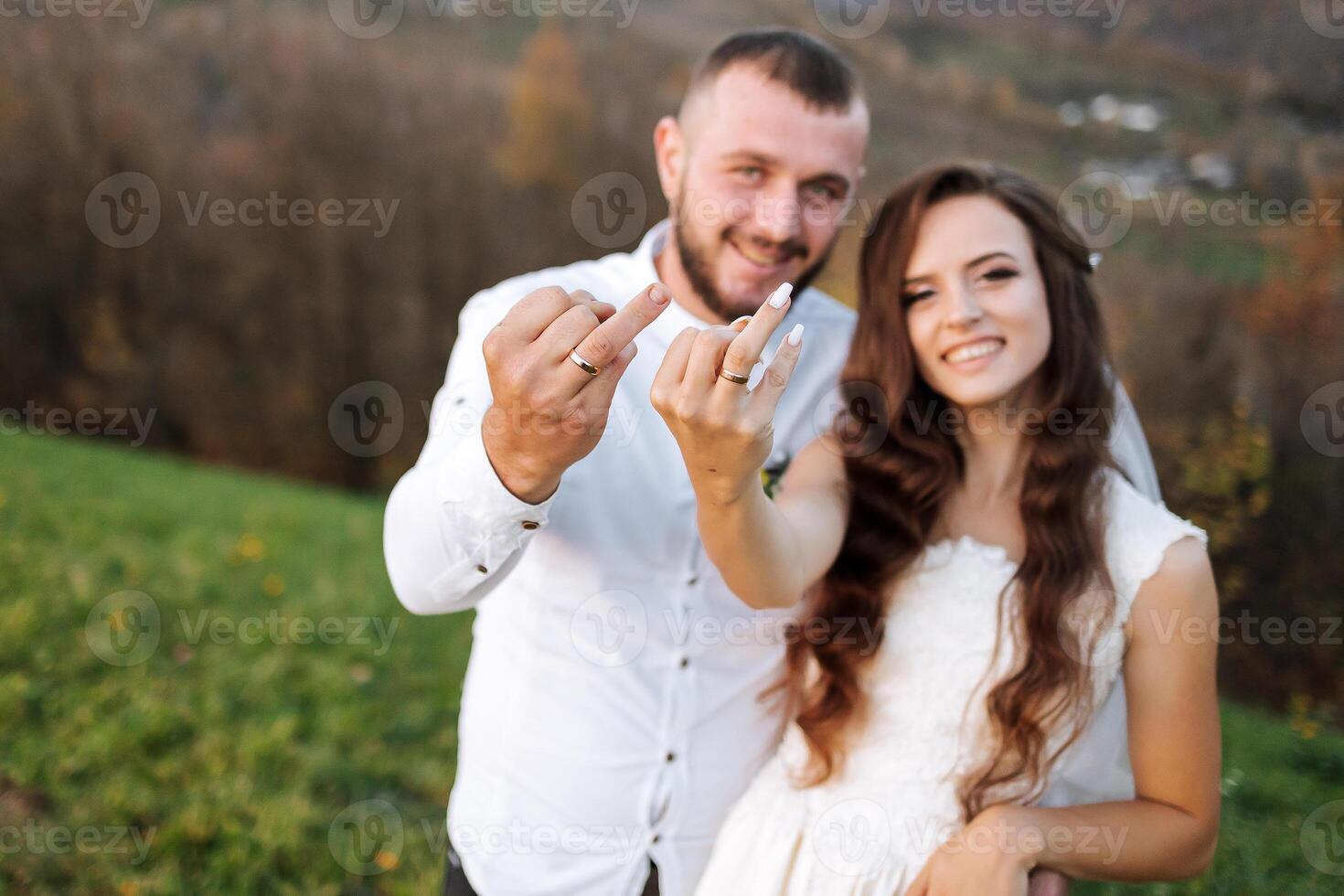 A man and woman are posing for a picture with their hands up in the air, one of them giving a thumbs up photo