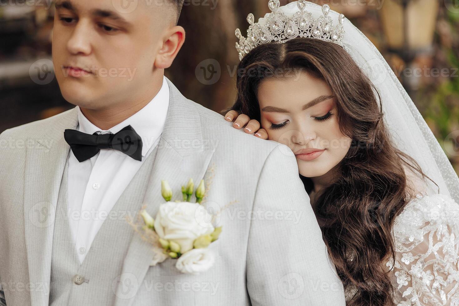 A bride and groom are hugging each other in a wedding photo