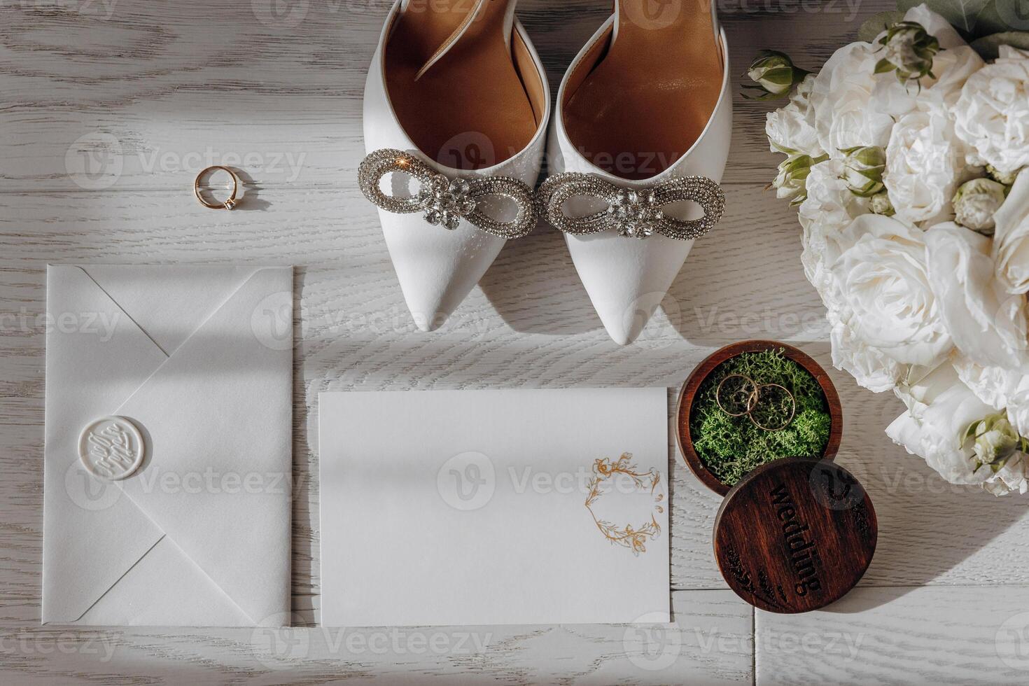 A pair of white shoes with a diamond band and a white card with a flower design on it photo