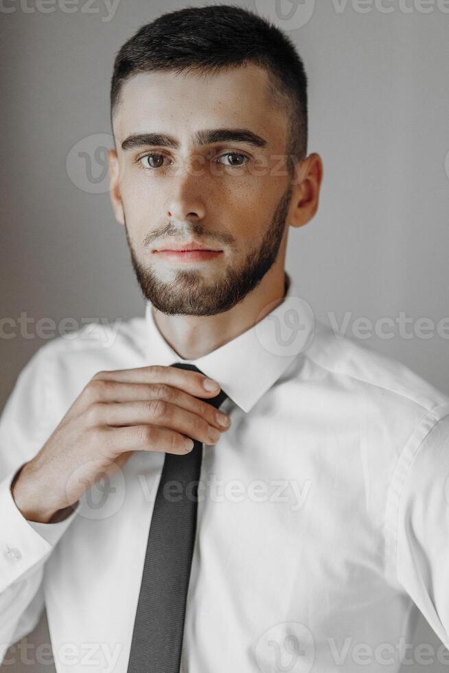A man in a white shirt and black tie is posing for a photo. The image has a blurred effect, giving it a dreamy or artistic feel. The man's facial expression photo