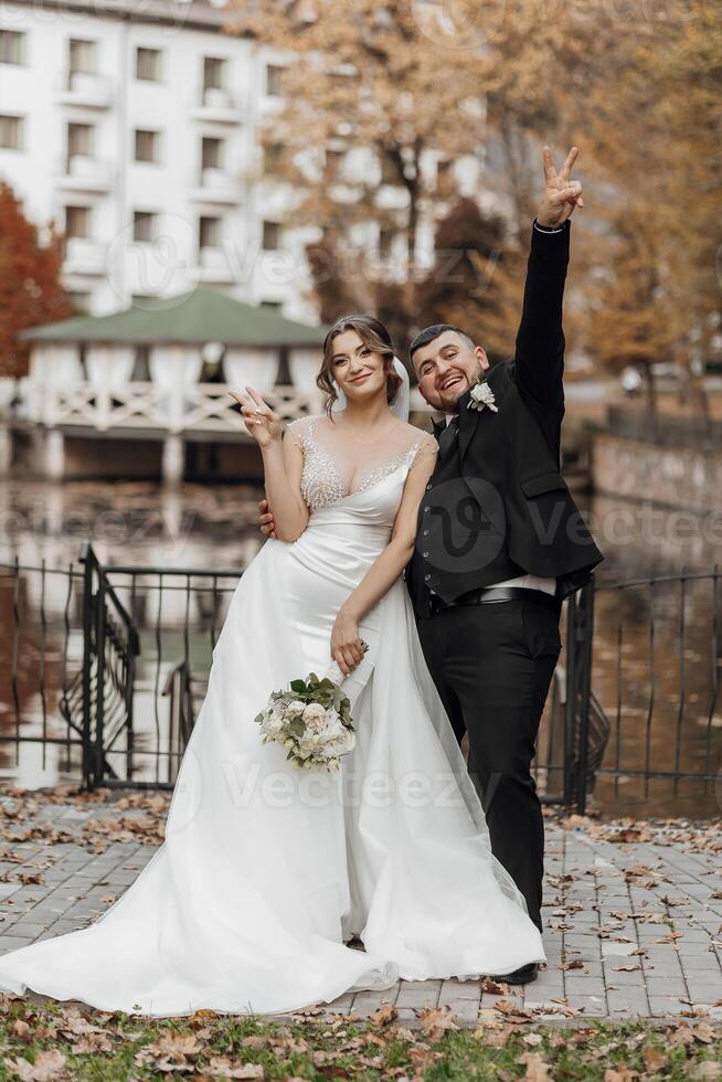 A bride and groom are posing for a picture with their hands on their hips photo