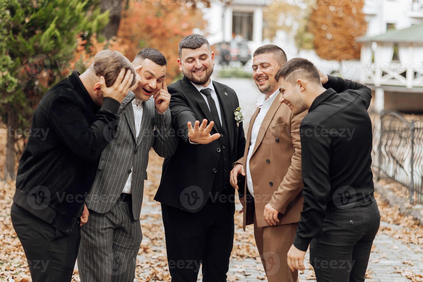 A group of men are posing for a picture, one of them is wearing a wedding ring photo