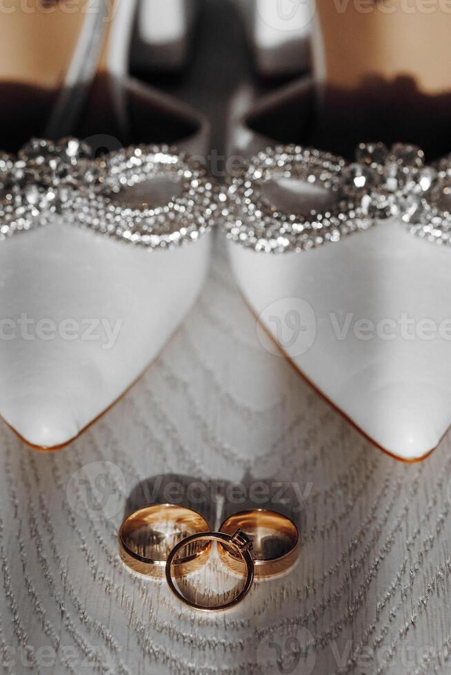 A pair of shoes with a gold ring on the left and a gold ring on the right photo