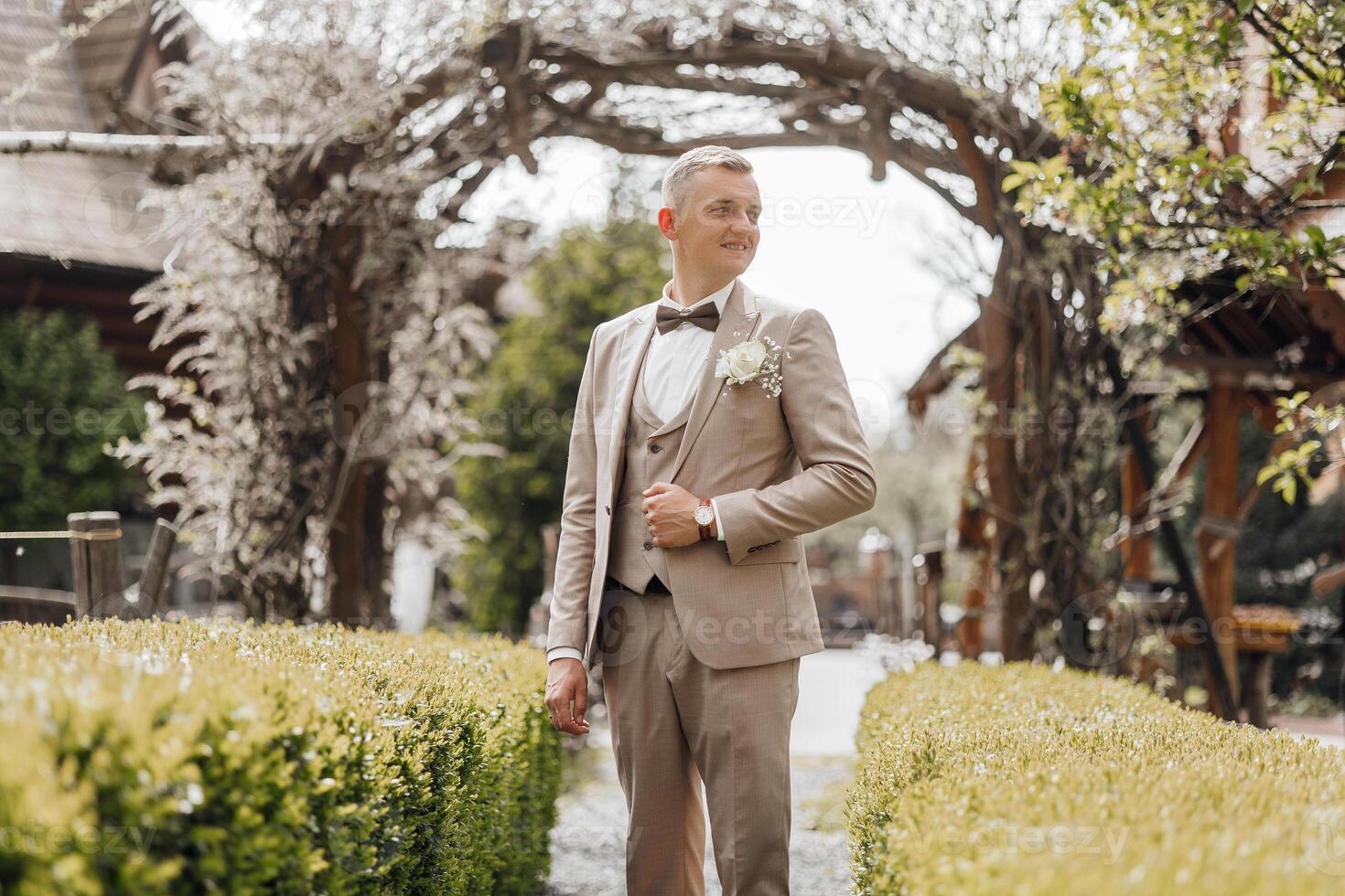 A man in a suit and tie stands in front of a gazebo photo