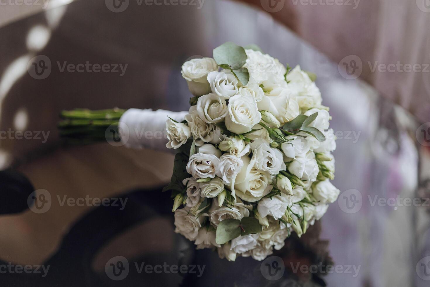 A bouquet of white flowers is displayed on a table photo