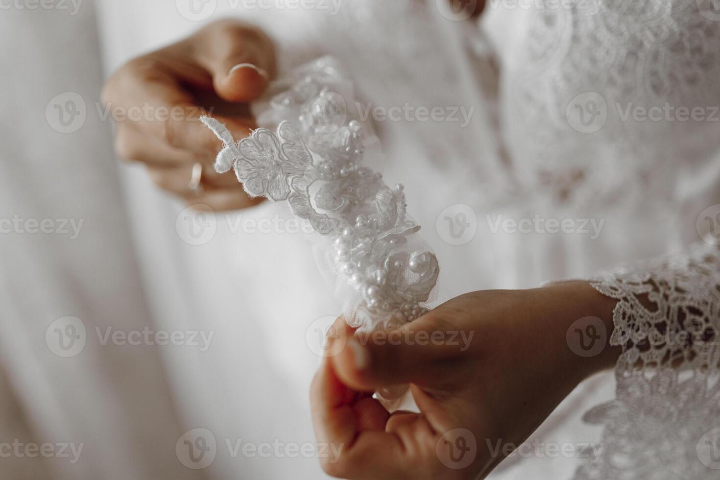 A woman is holding a white lace headband. The lace is delicate and intricate, and the woman is holding it with care. Concept of elegance and sophistication photo