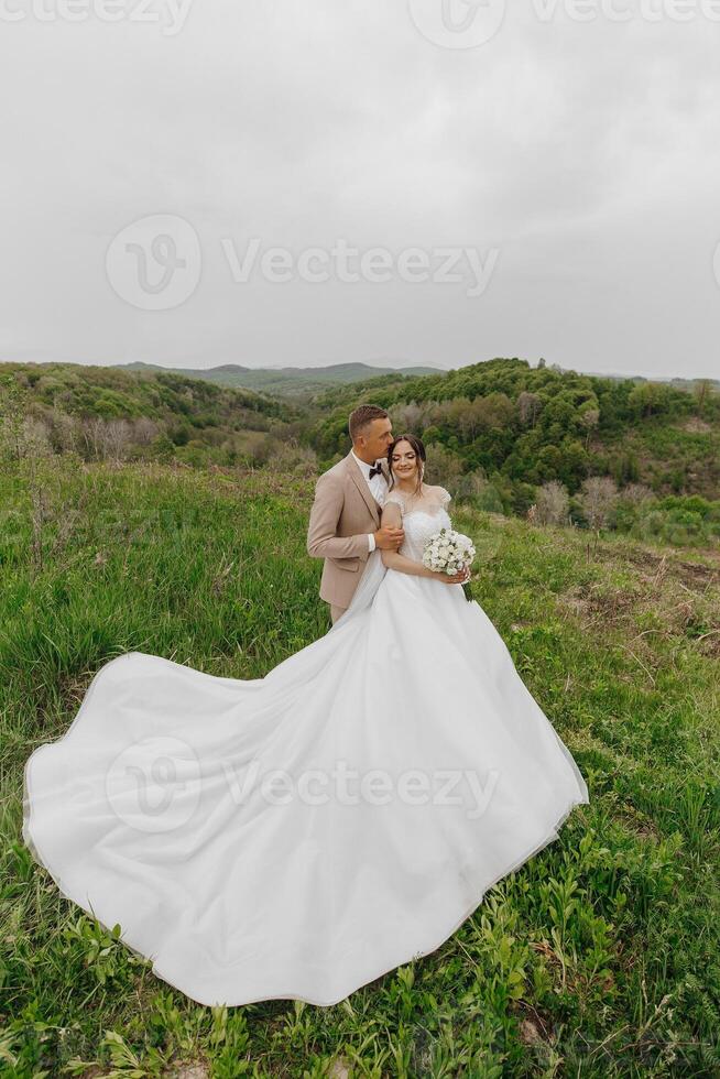 A bride and groom are standing in a field photo