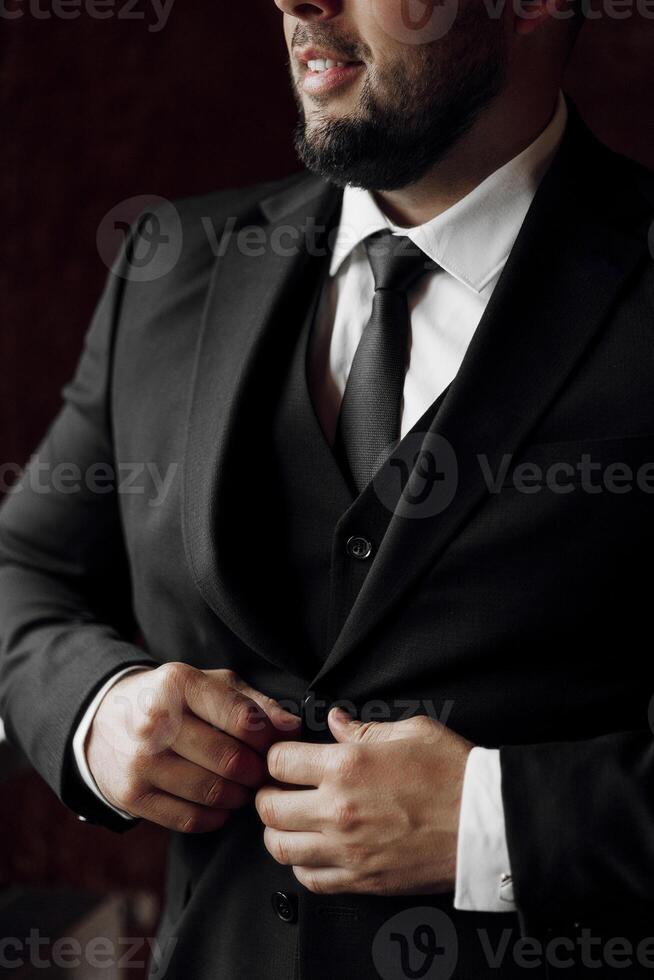 A man in a suit is getting ready for a formal event. He is adjusting his tie and jacket, making sure everything is in place. Concept of professionalism and attention to detail photo