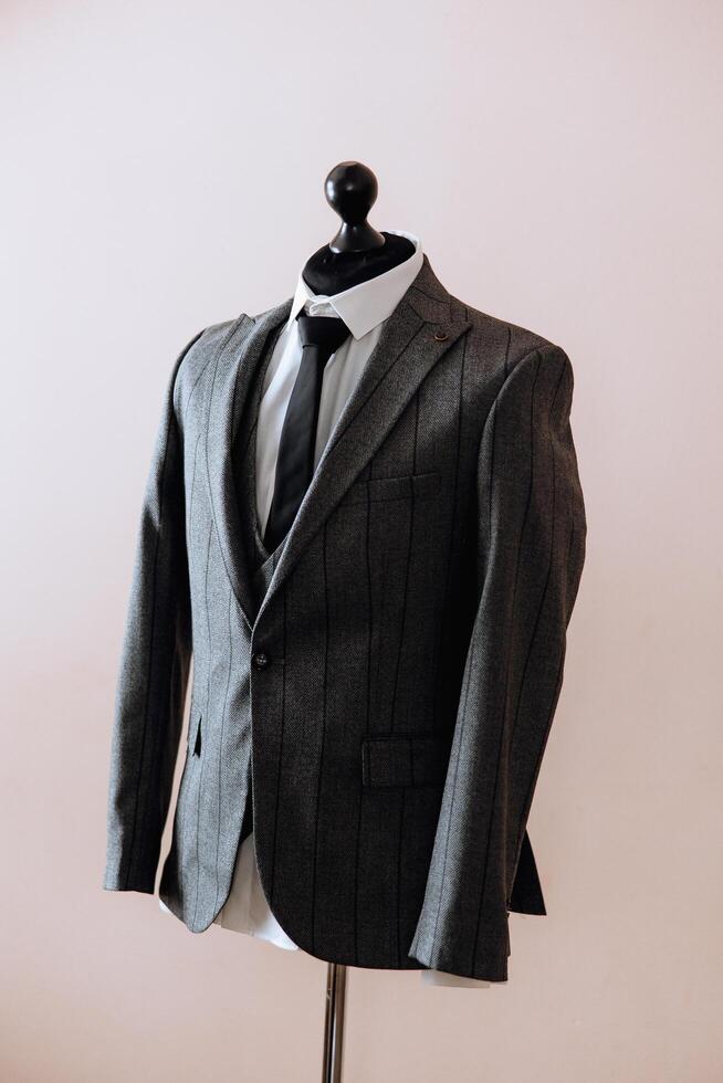 A man is wearing a black tie and a gray jacket. The jacket has a pattern of snakes on it photo