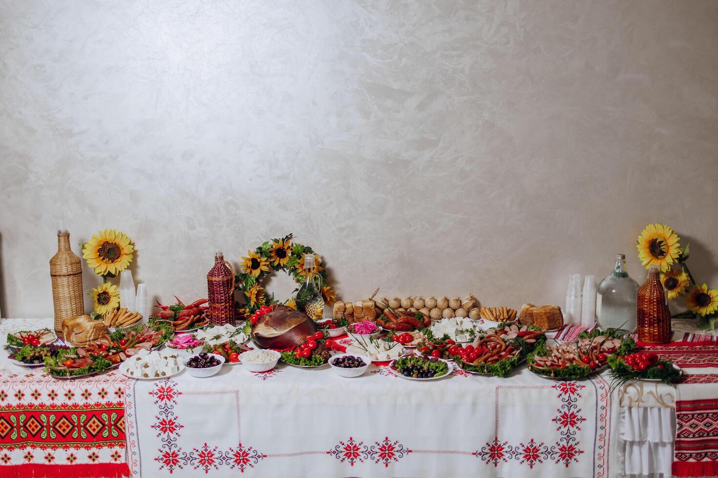 A table is covered with a variety of food and drinks, including a bowl of fruit photo