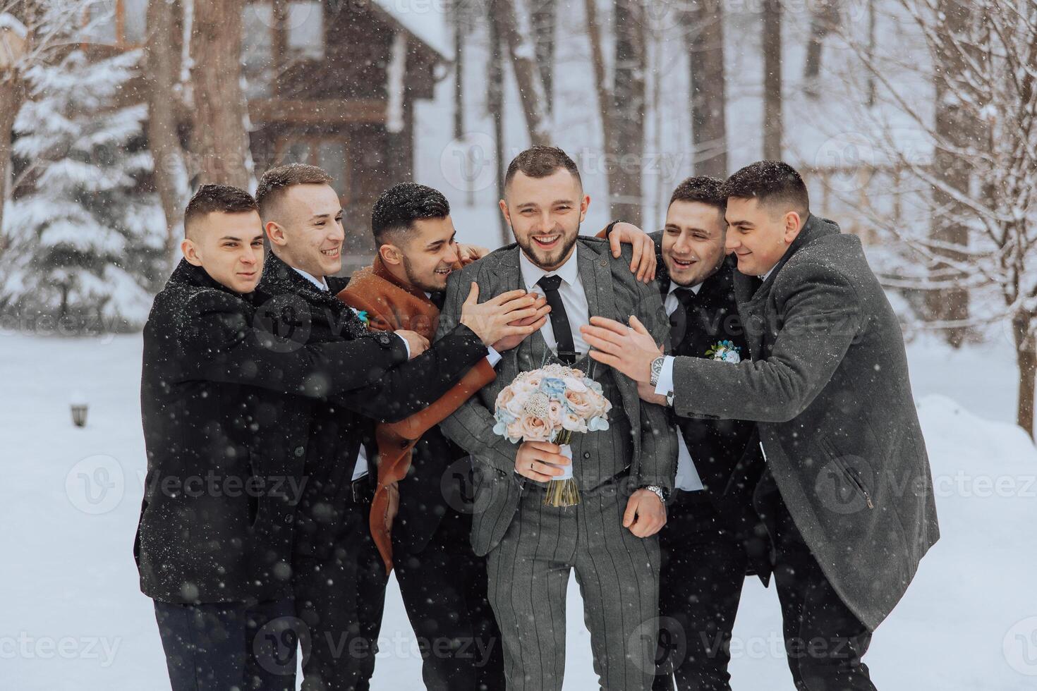 A group of men are posing for a picture in the snow, with one man holding a bouquet of flowers. Scene is festive and joyful, as the men are dressed up and smiling for the camera photo