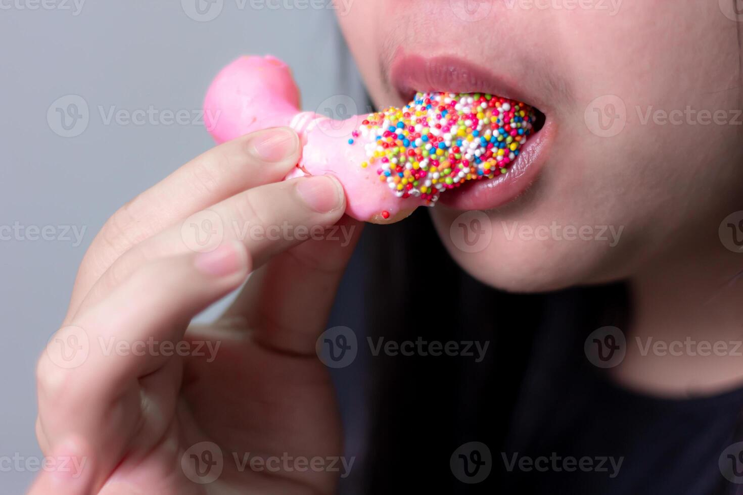 Close up, Woman eating strawberry donut blurred background photo