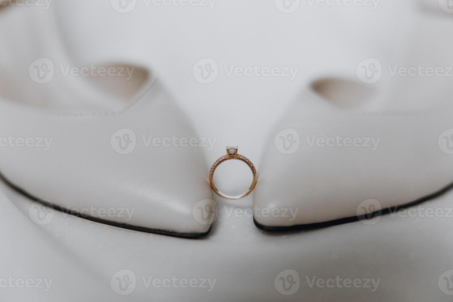 A ring is placed on a pair of white shoes photo