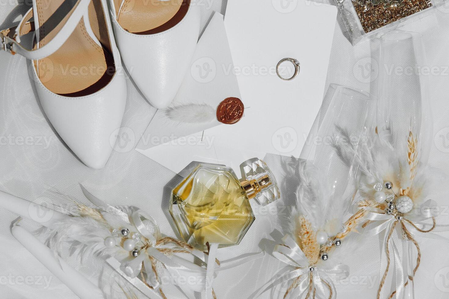 A pair of white shoes and a bottle of perfume are on a table photo
