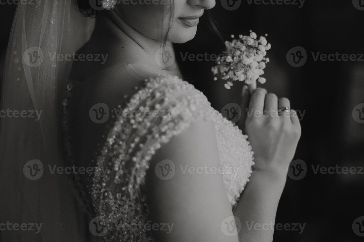 A woman is wearing a wedding dress and holding a flower. The image has a romantic and elegant mood photo