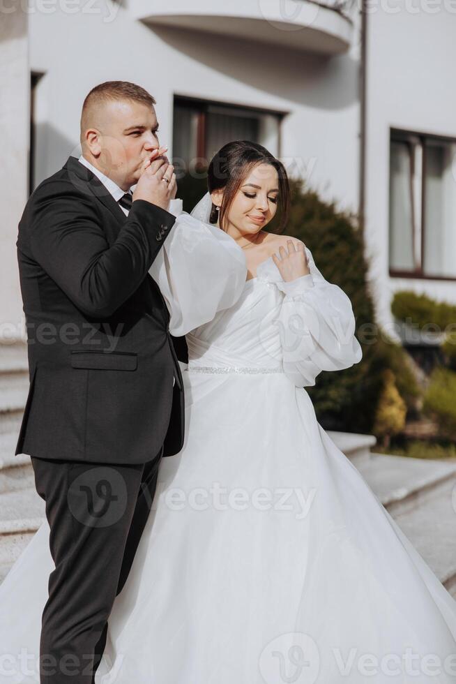 A bride and groom are standing on a staircase photo