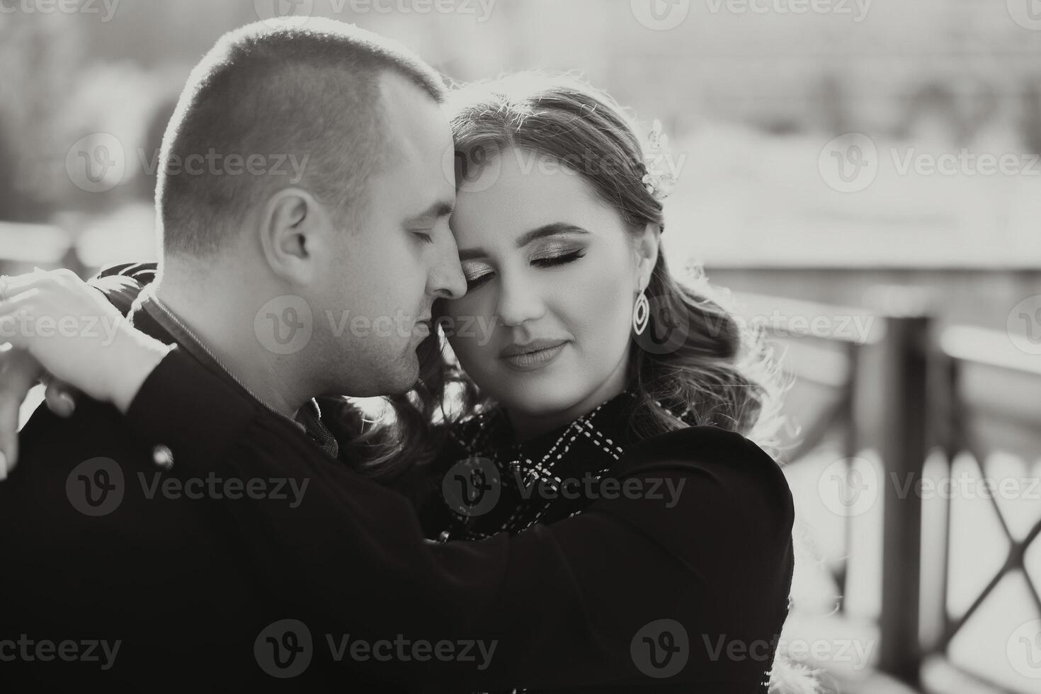 A man and woman are hugging each other on a bridge photo