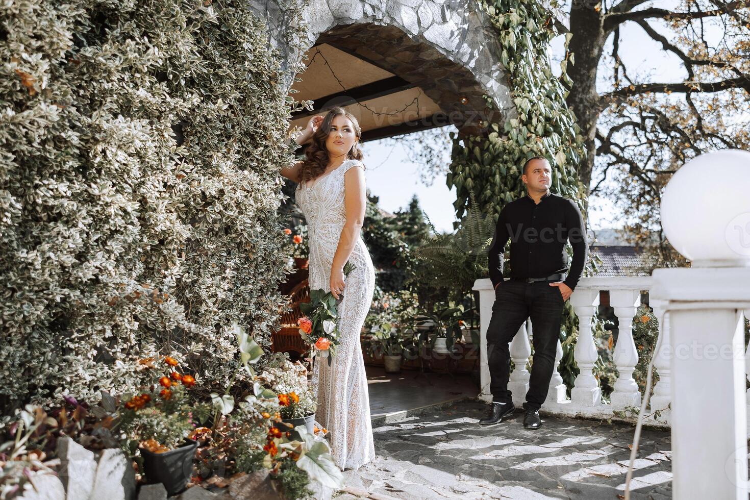 A man and woman are standing in front of a building with a white railing photo