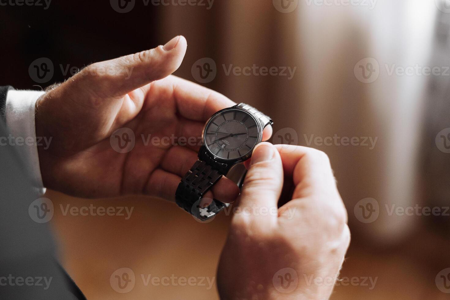 A man is holding a watch in his hand photo