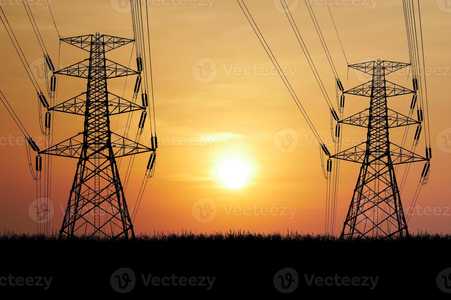Silhouetted Power Lines and Transmission Towers at Sunset with Vibrant Orange Sky and Sun in Background photo