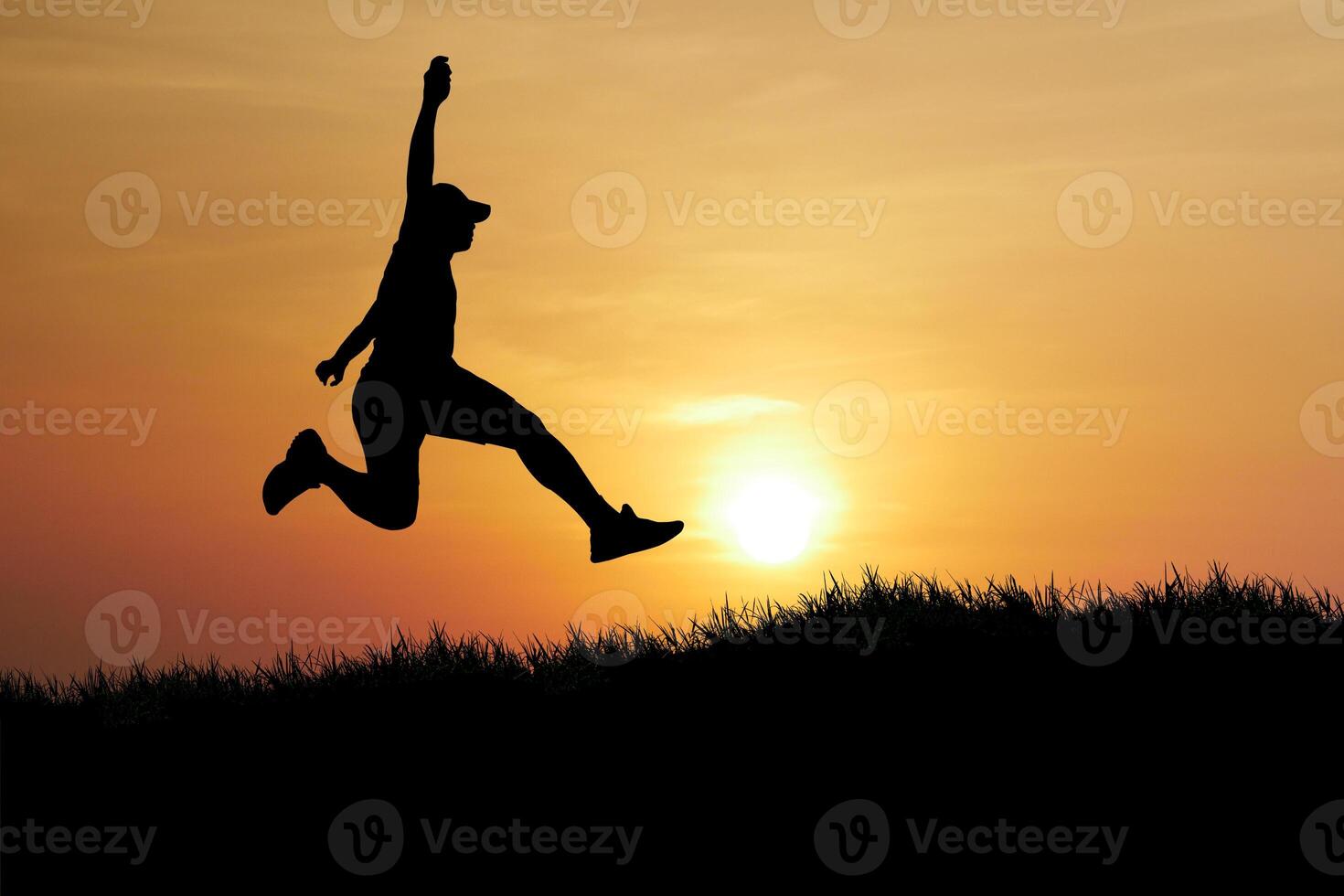 Silhouette of a Person Jumping Against a Beautiful Sunset Sky in a Natural Landscape photo