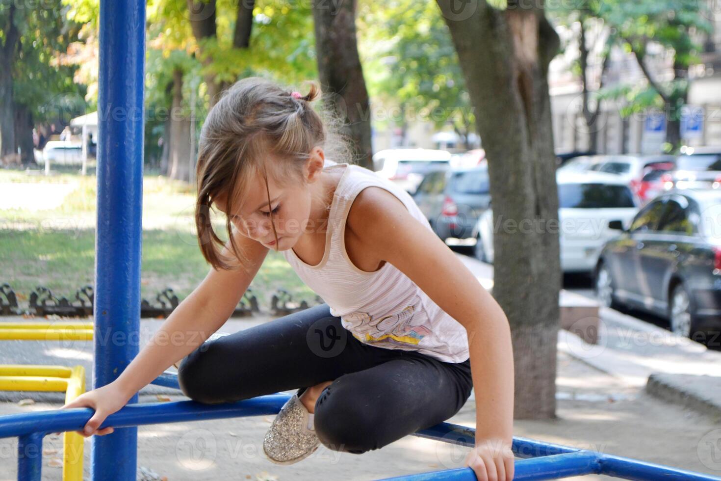 The girl goes in for sports on the Playground on the street. photo
