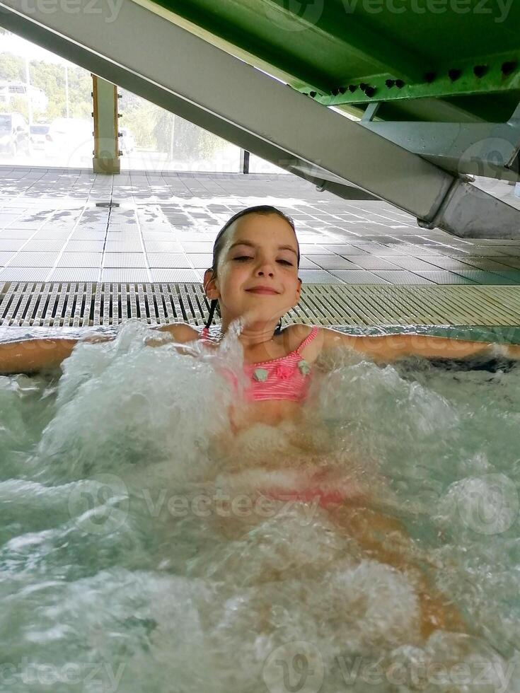 A child looks at the foam bubbles in the pool photo