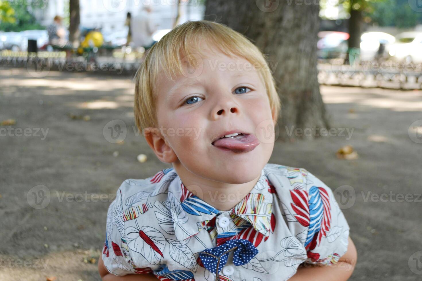 Blond boy 4 years old playing on a children playground and has fun. photo