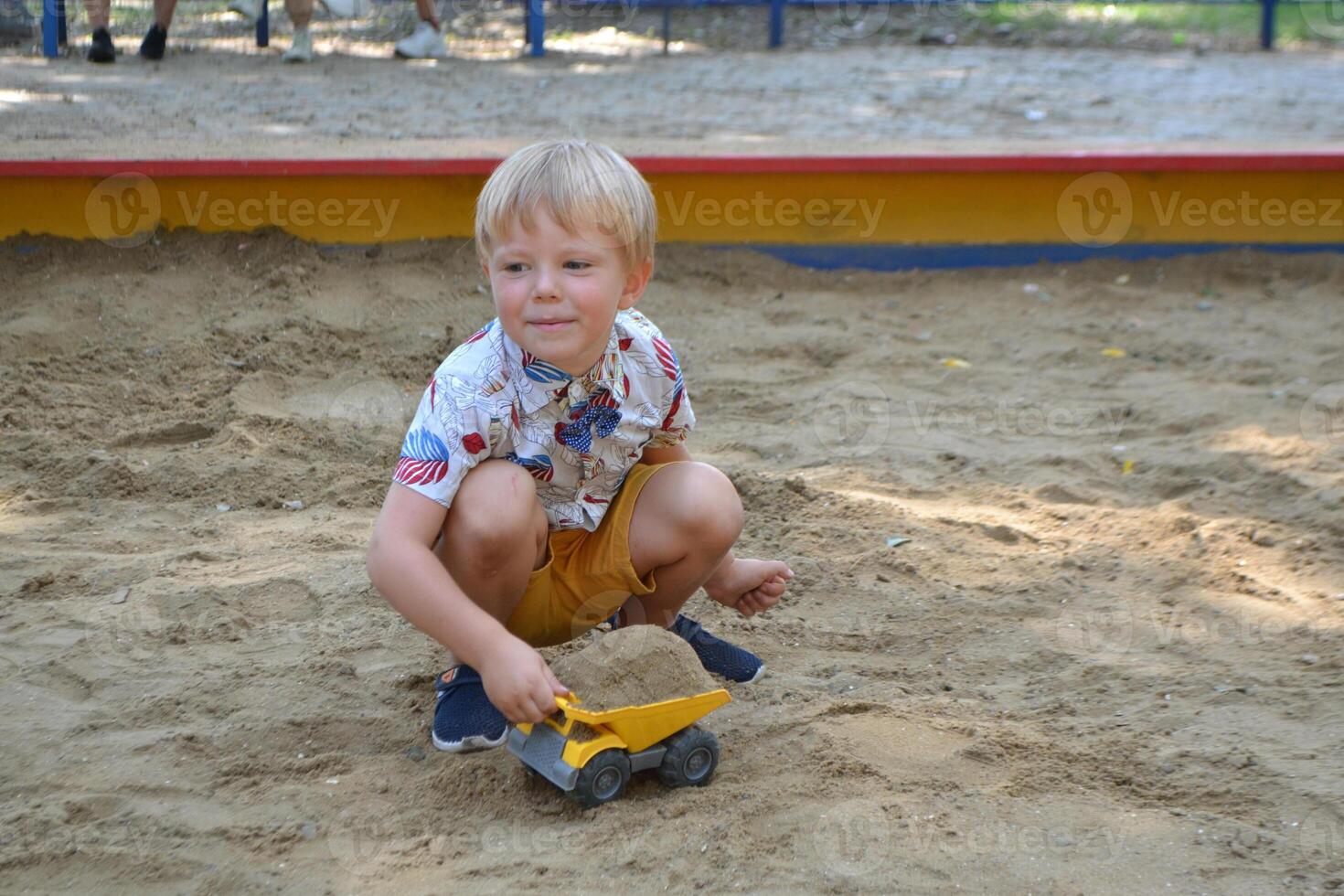 Cute toddler boyl playing in sand on outdoor playground. photo