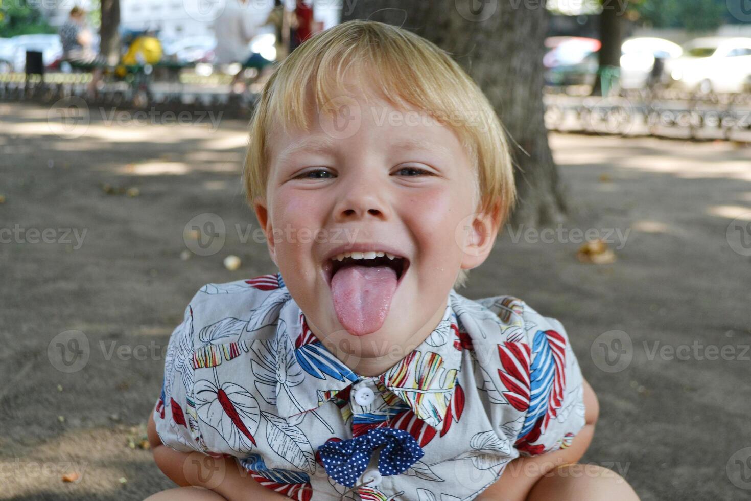 Blond boy 4 years old playing on a children playground and has fun. photo