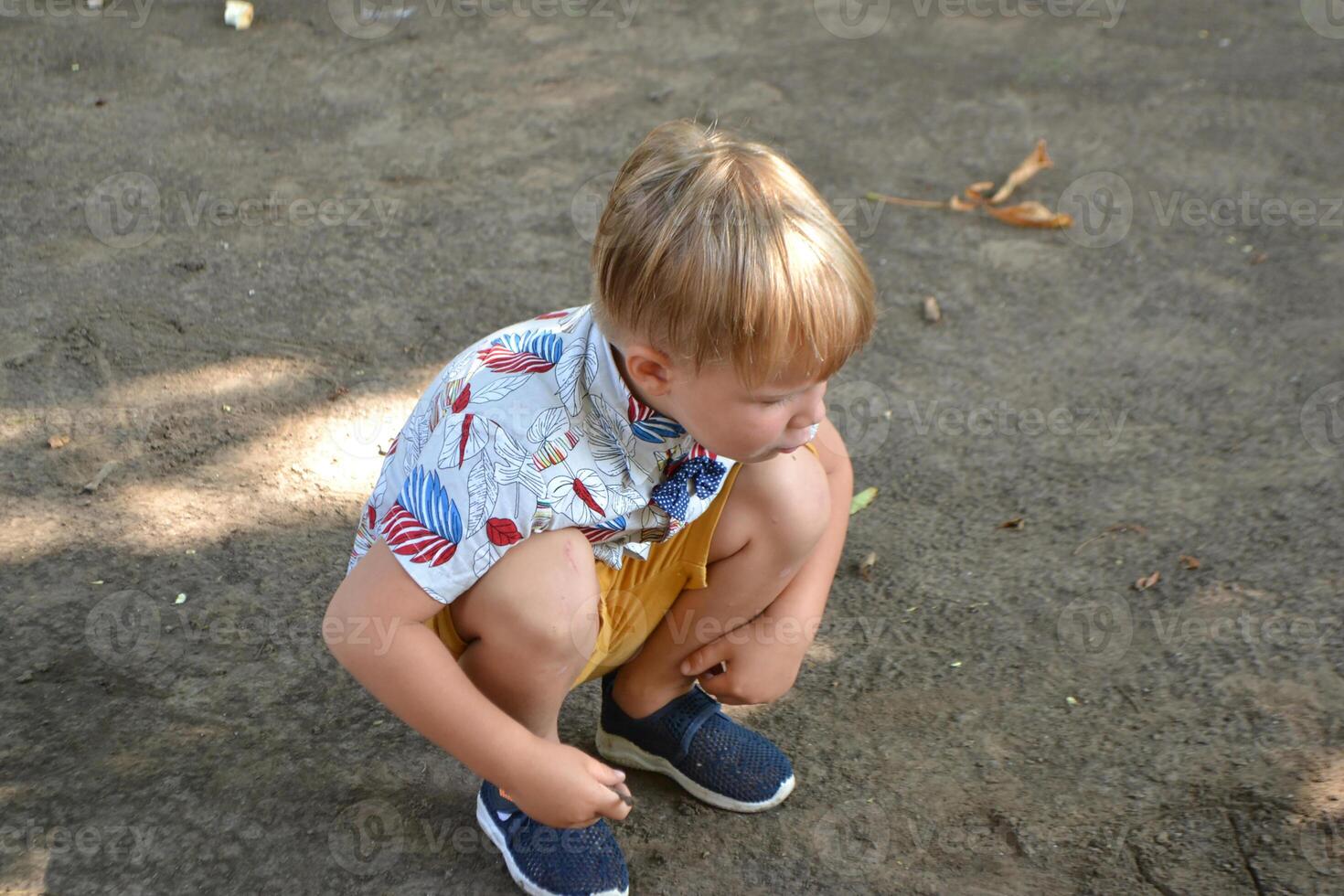 a little boy wearing a shirt with a bow tie is sticking out his tongue photo