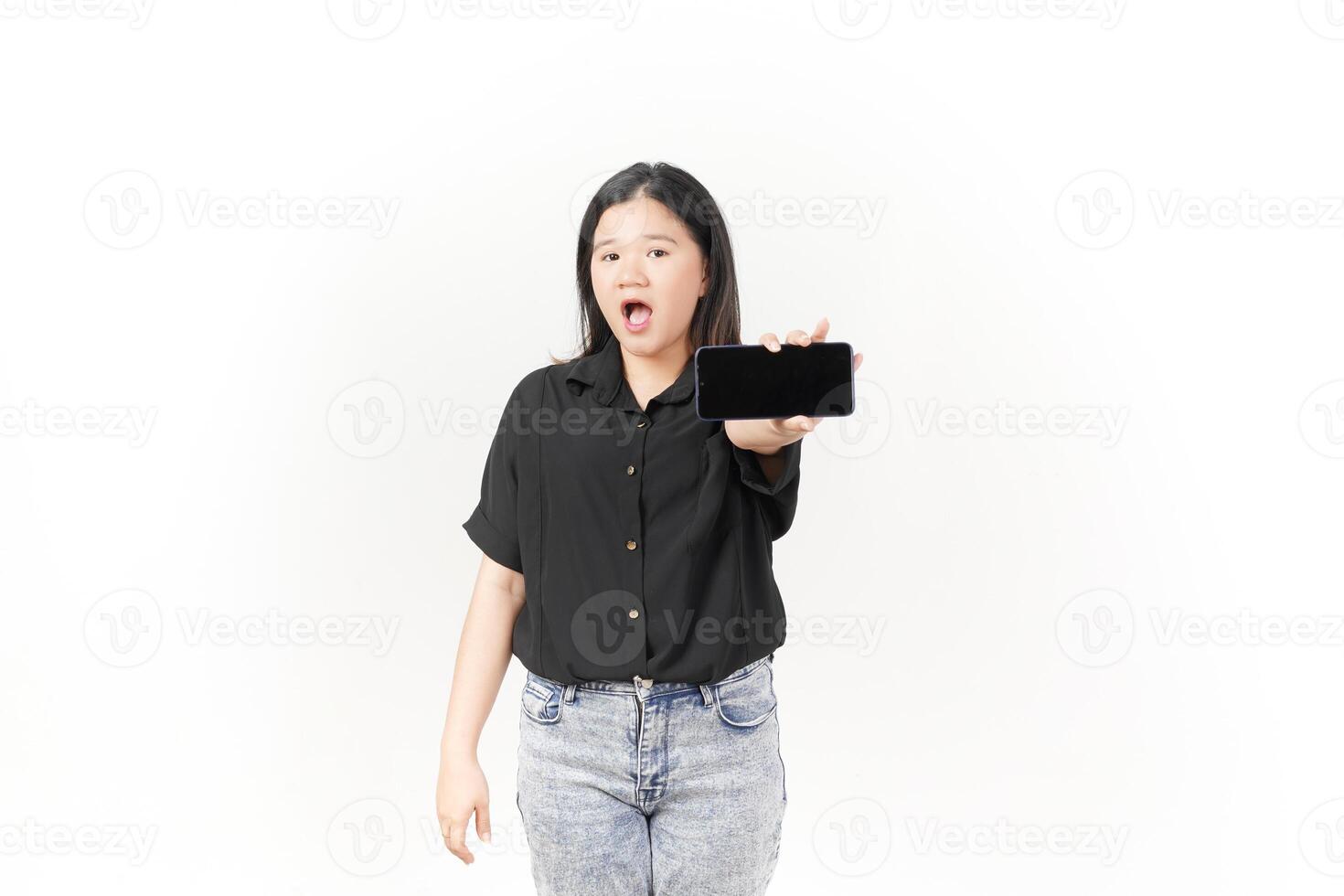 Young Asian woman presenting blank screen of Smartphone wearing Black t-shirt and jeans isolated on white background photo