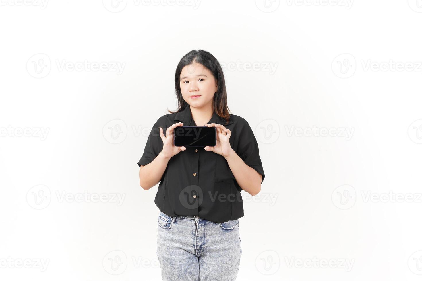 Young Asian woman presenting blank screen of Smartphone wearing Black t-shirt and jeans isolated on white background photo